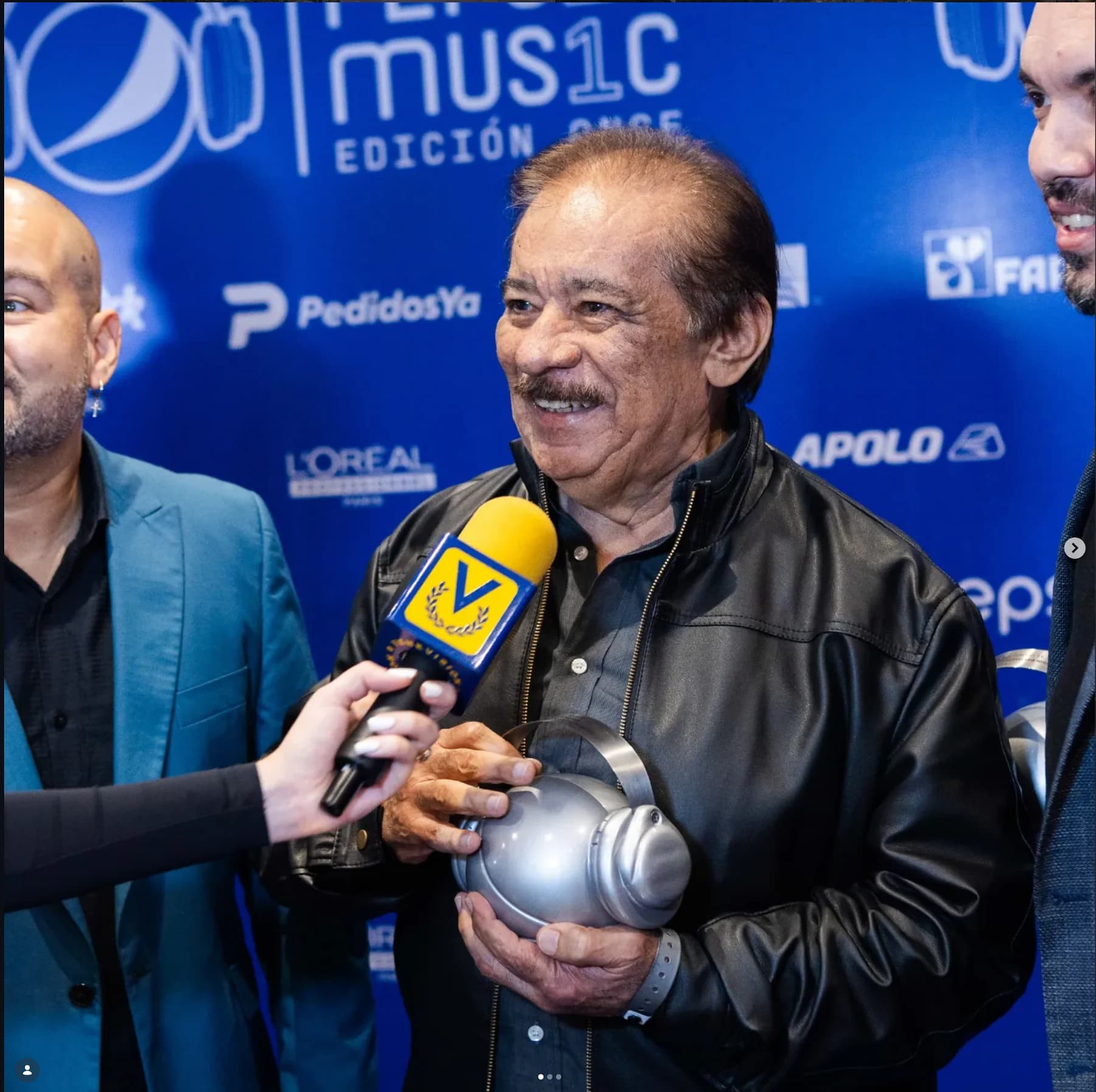 Betulio Medina durante una entrevista en los Premios Pepsi Music 2023, sosteniendo el reconocimiento recibido.